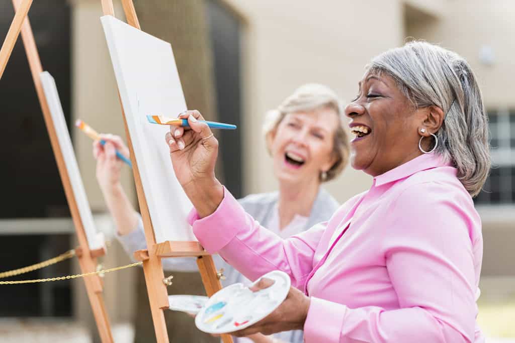 inspired-living-assisted-living-two-senior-women-having-fun-painting-in-art-class-1200px
