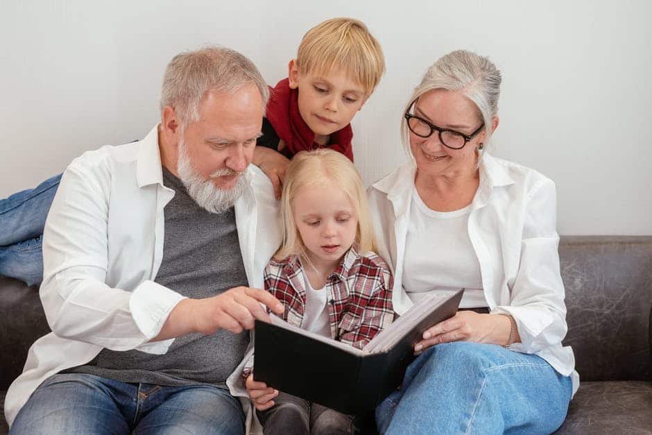 Grandparents and grandkids looking at a book together