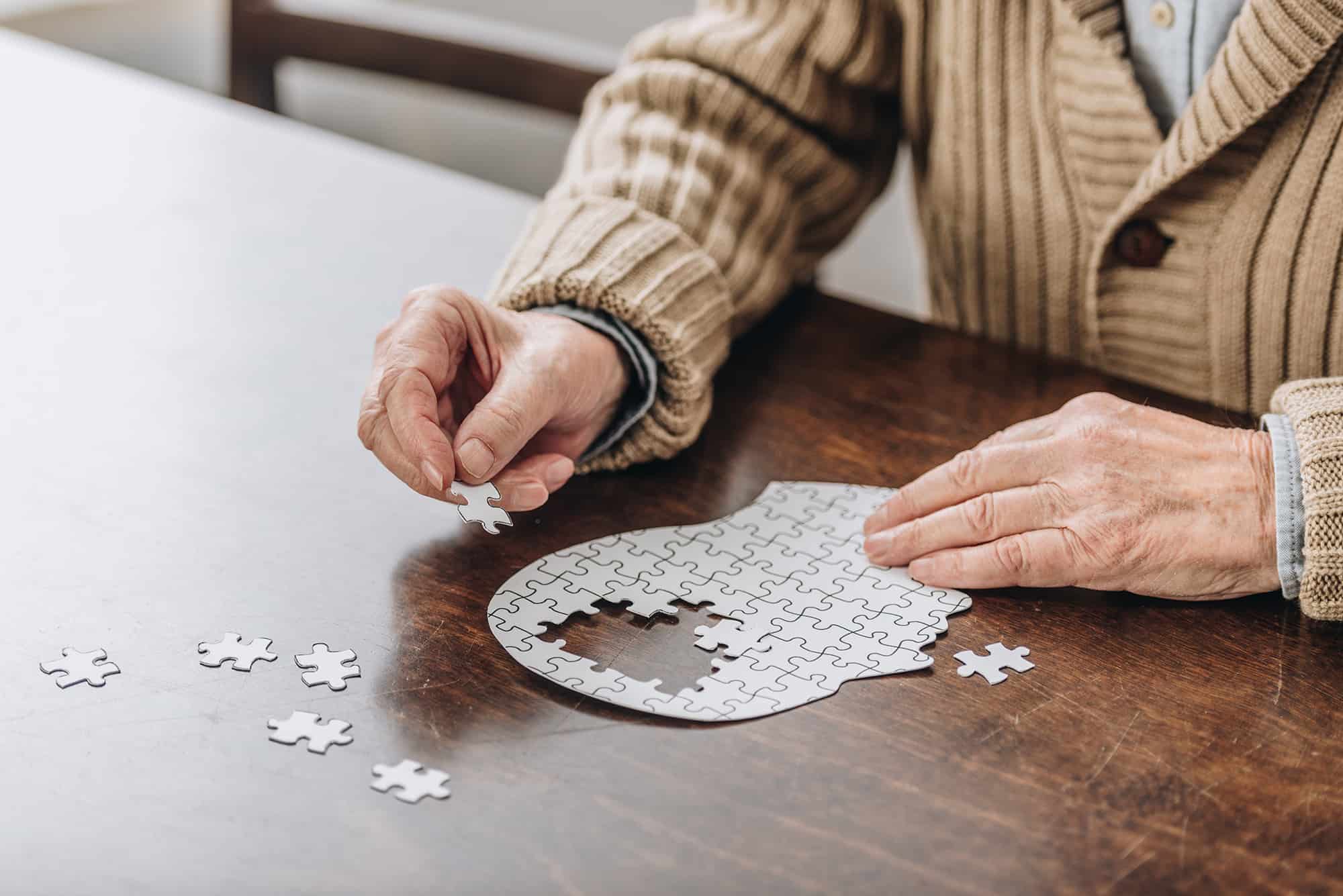 What is dementia? Senior Citizen putting together a puzzle of a brain