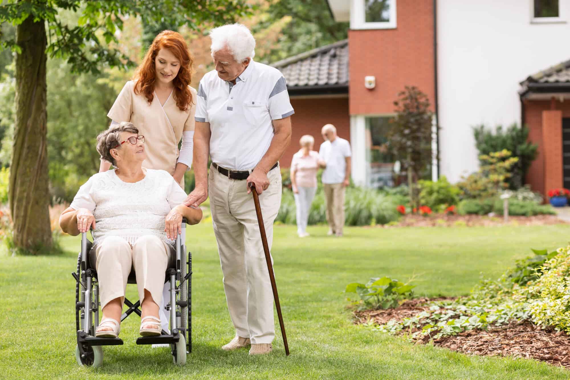 Senior citizens and caretaker taking a walk outside